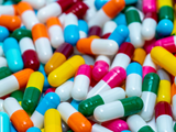 A pile of brightly coloured medicine capsules that appear to be antibiotics