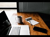 Office desk with laptop and notepad