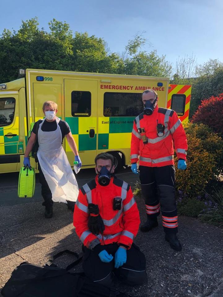 Emergency workers posing in front of ambulance